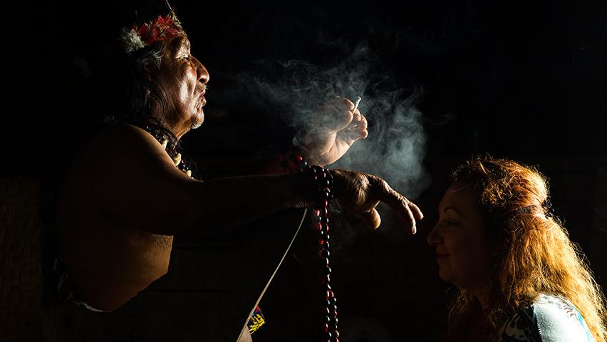 ancient Mayan shaman using plants for cultural healing on woman