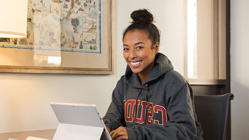 Happy CSUDH student with tablet